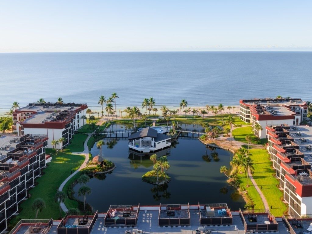 Ein Resort mit mehreren Gebäuden, einem zentralen Wasserspeicher und Palmen.