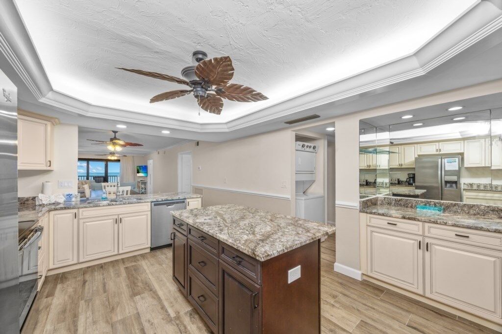 A spacious kitchen with granite countertops, wooden cabinets, and a central island.