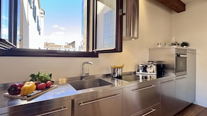 A modern kitchen with stainless steel appliances, a large window, and a view of buildings outside. - Saoner Prestige - Historical Center (Venecia)