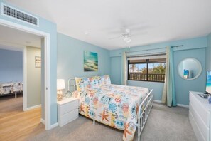 Une chambre à coucher comprenant un lit, une table de chevet, une commode et une fenêtre donnant sur un paysage agréable.