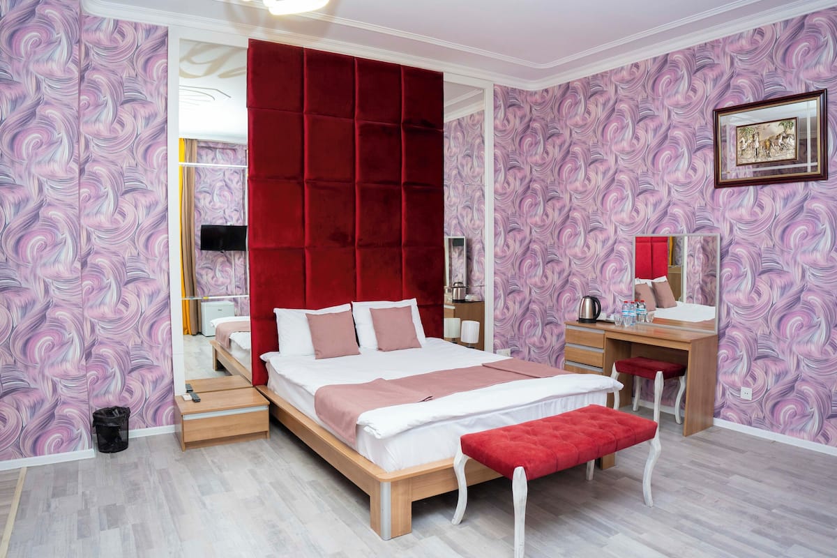 Une chambre à coucher moderne avec un grand lit, un bureau et une chaise.