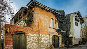 A traditional building with a stone facade, wooden doors, and a brick upper section. - Vila Terrasse (Kosice)
