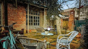 A patio with wicker chairs, a table, and a bicycle. - Vila Terrasse (Kosice)