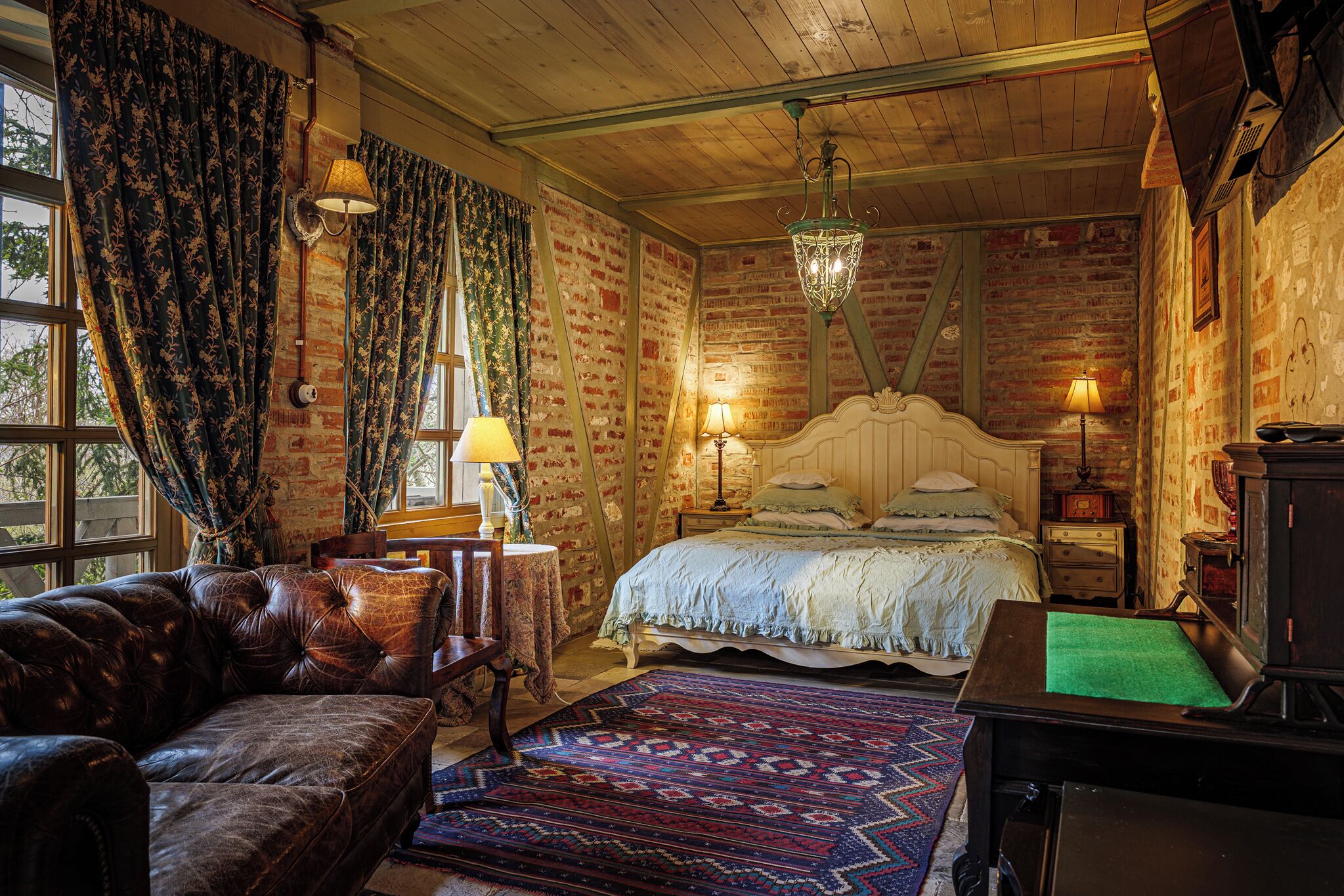 Una camera accogliente con un letto grande, un divano in pelle e un tavolo da biliardo.