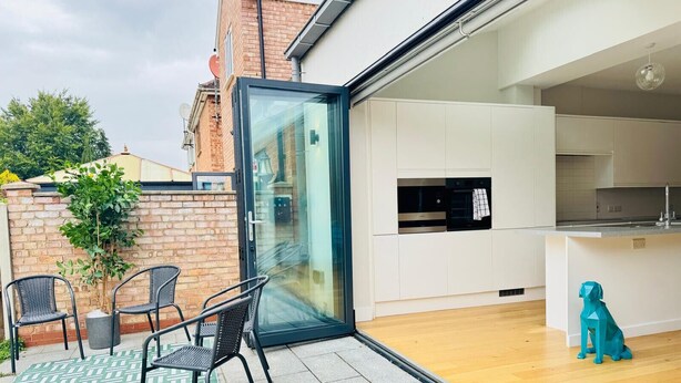 A modern kitchen with white cabinets, a built-in oven, and a wooden floor. - Heliodor House in Cambridge (Cambridge)