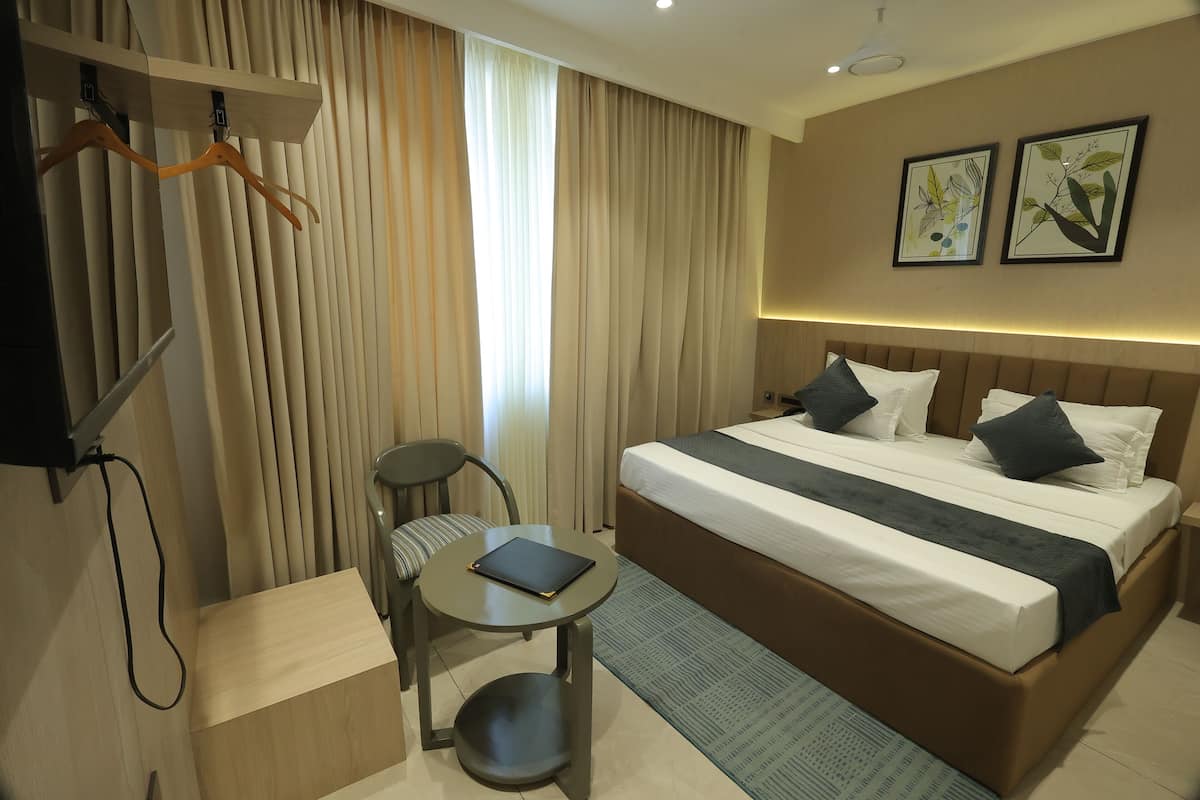 Une chambre d’hôtel moderne avec un grand lit, une petite table, une chaise et un bureau.