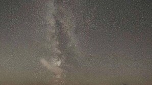 A geodesic dome structure with a fire inside, set against a starry night sky.