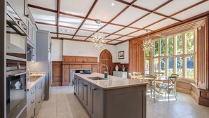 A spacious kitchen with a large island, wooden cabinets, and a built-in oven.