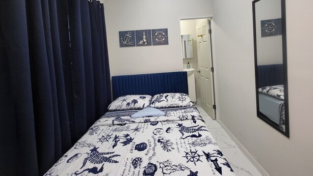 Une chambre à coucher avec un lit, un miroir et une porte.