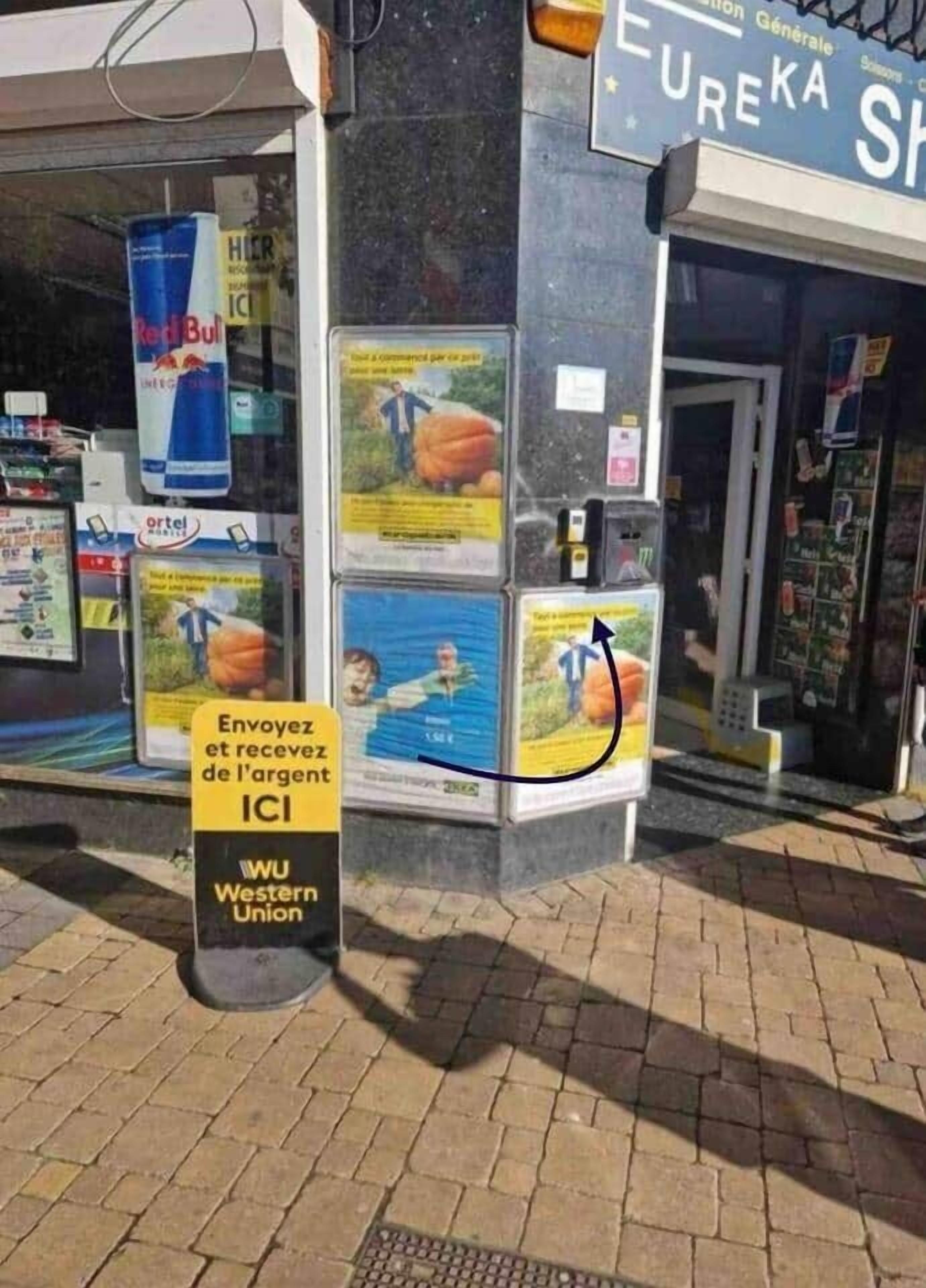 Ein Ladenlokal mit verschiedenen Werbeanzeigen, einem Schild für ICI und einem Western Union Geldtransfer-Service.
