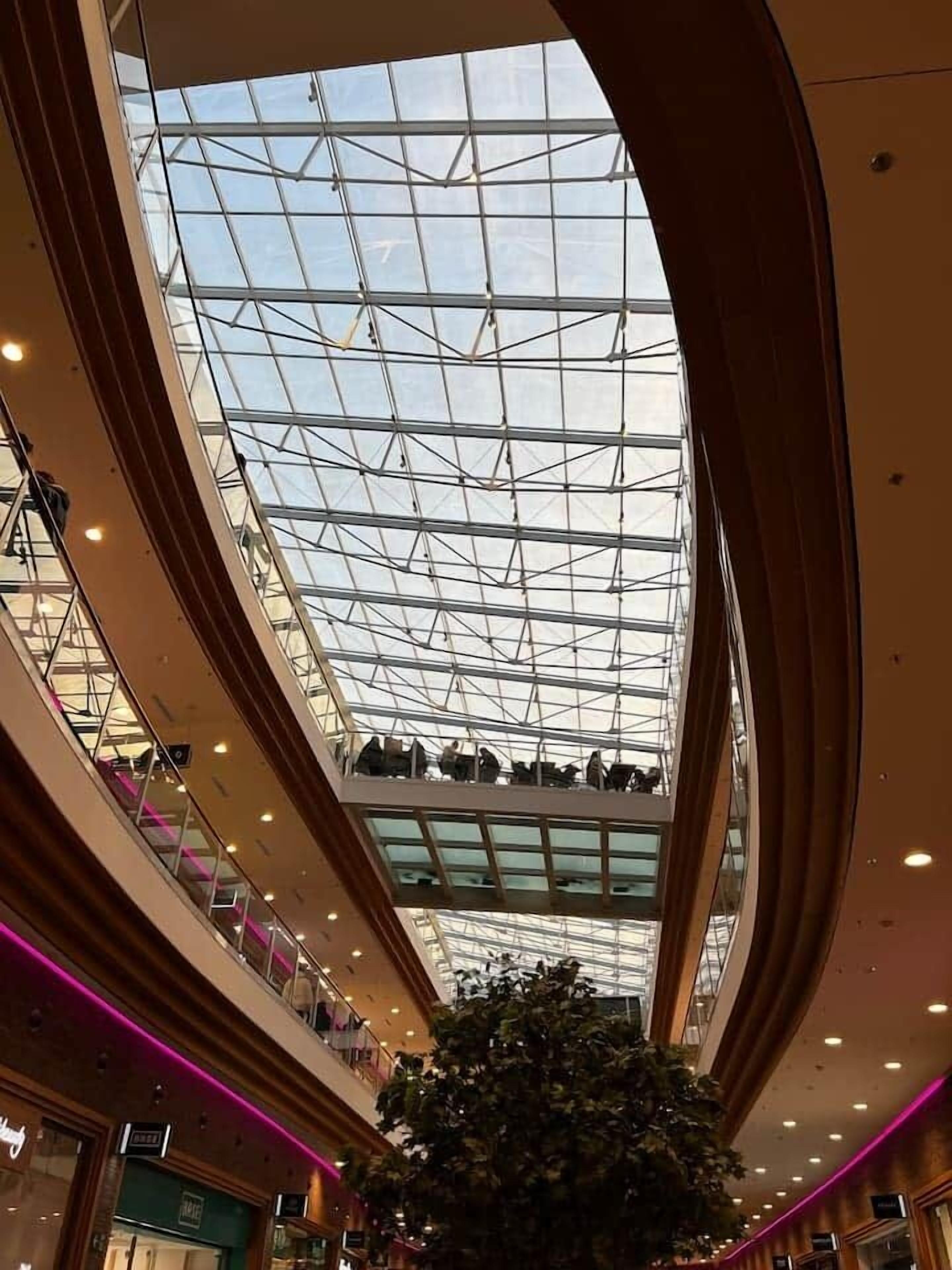 Un centro comercial de varios niveles con techo de cristal y un atrio central.