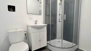 Ein Badezimmer mit Toilette, Waschbecken und einer Duschkabine.