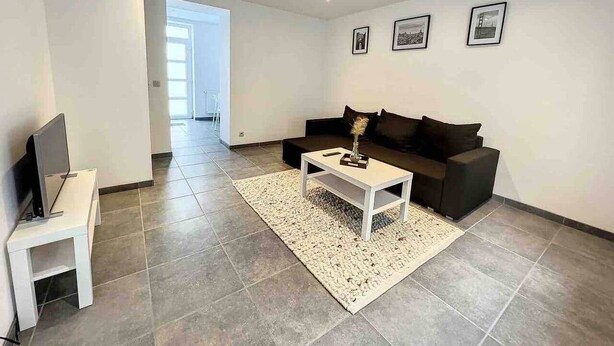 En moderne stue med sofa, sofabord og TV-møbel.
