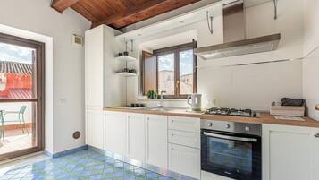 Apartamento, 1 cama de casal e sofá-cama, vista para a cidade | Cozinha privada | Geladeira, fogão, cooktop, talheres/pratos/utensílios de cozinha