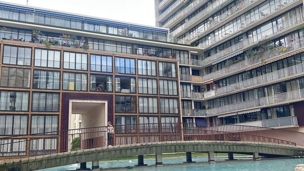 A modern building with multiple balconies and a central courtyard with a water feature. - Panoramic Paris Views - 3BR Near Eiffel Tower & Seine (Boulogne-Billancourt)