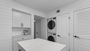 A laundry room with a washing machine, dryer, and a countertop.
