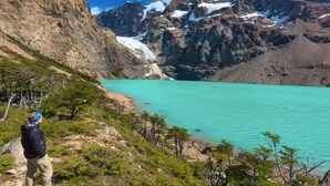 A mountainous landscape with a turquoise lake, rocky terrain, and sparse vegetation. - Hosteria Helsingfors (Estancia Helsingfors)