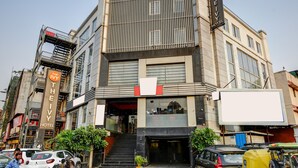 Ein Hotel mit einer modernen Fassade, einem markanten Eingang und einer Treppe zum Eingang.