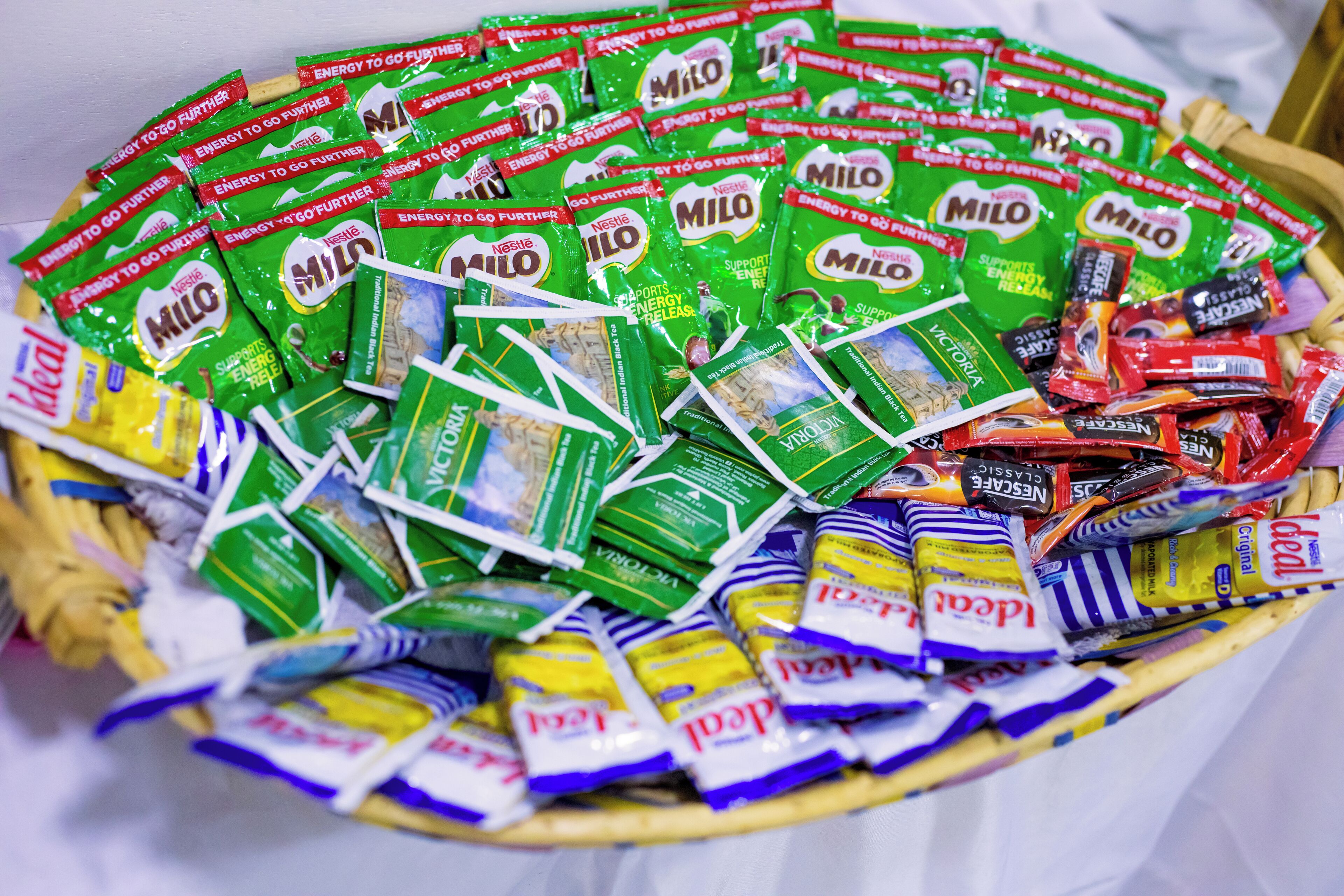 Een mand gevuld met verschillende zakjes snacks, waaronder Milo en andere merken.