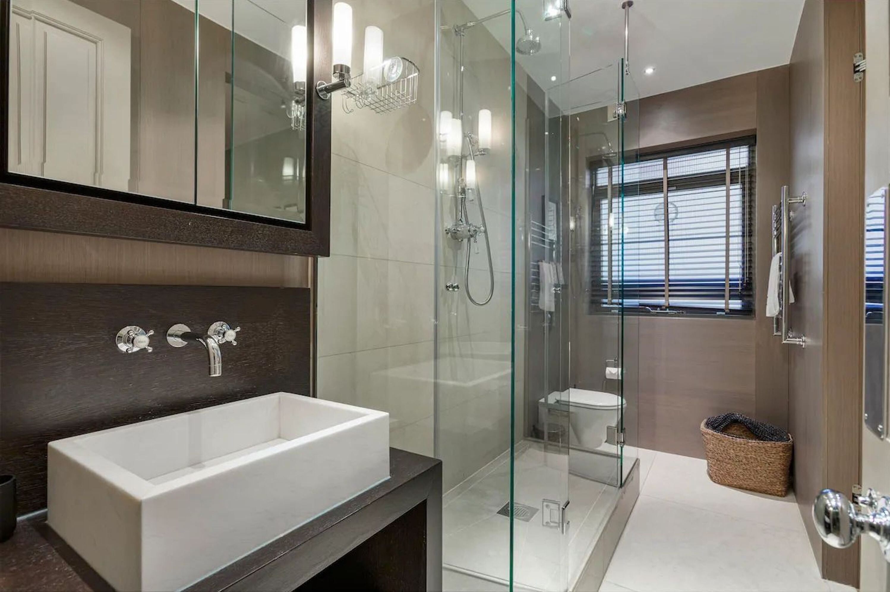 A modern bathroom with a glass-enclosed shower, a standalone bathtub, and a toilet.
