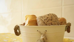 A metal bucket filled with various breads and a decorative keychain. - #320 Family Apartment in the City Center (Albufeira)