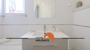 A modern bathroom with a white sink, mirror, and towel rack. - #320 Family Apartment in the City Center (Albufeira)