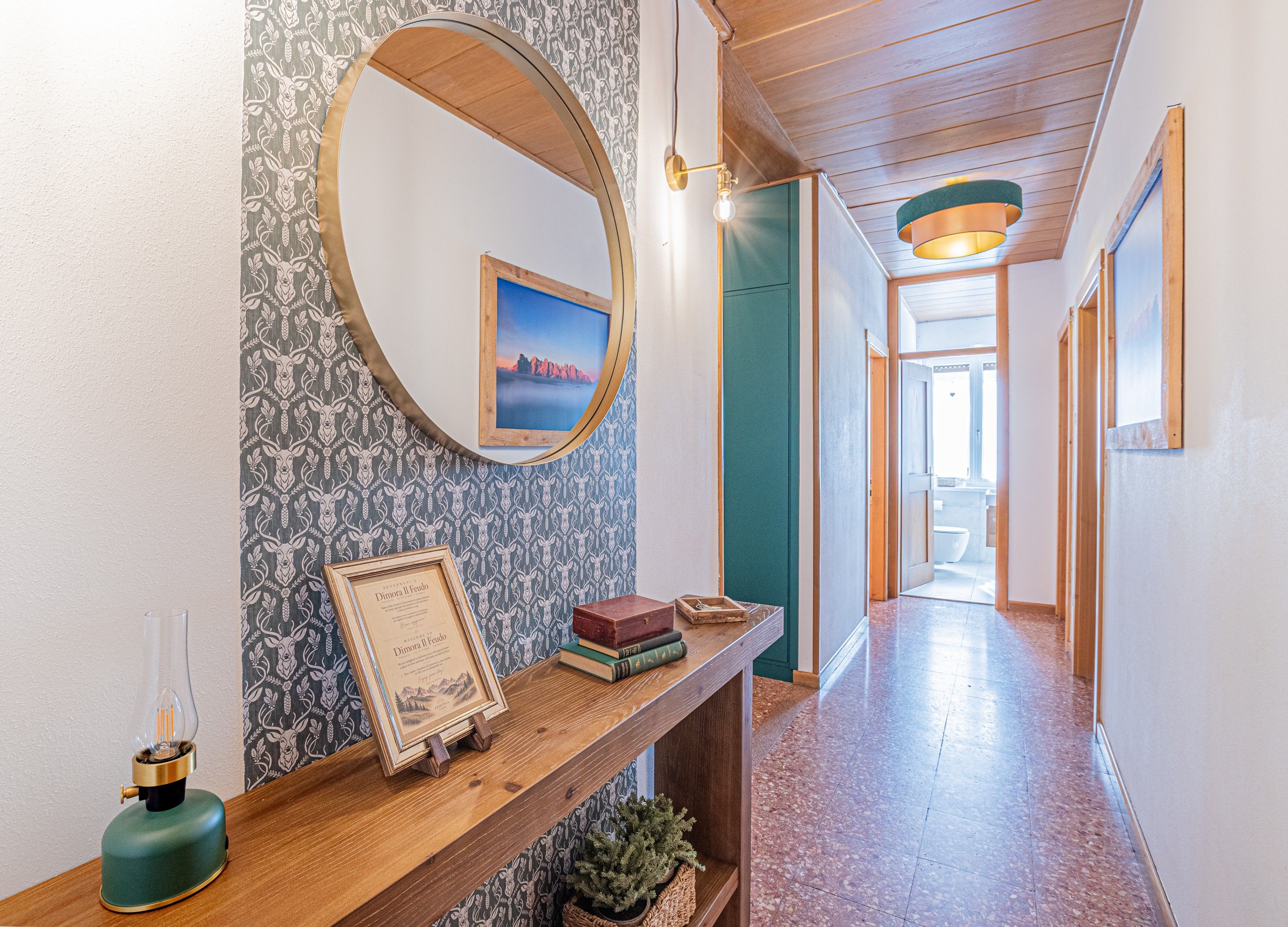 A hallway with a wooden bench, a framed certificate, a small plant, and a mirror on the wall.