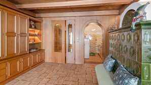 A room with wooden cabinets, a green upholstered bench, and a tiled floor. - Apartment 'Il Feudo' with Mountain View, Balcony and Wi-Fi (Predazzo)