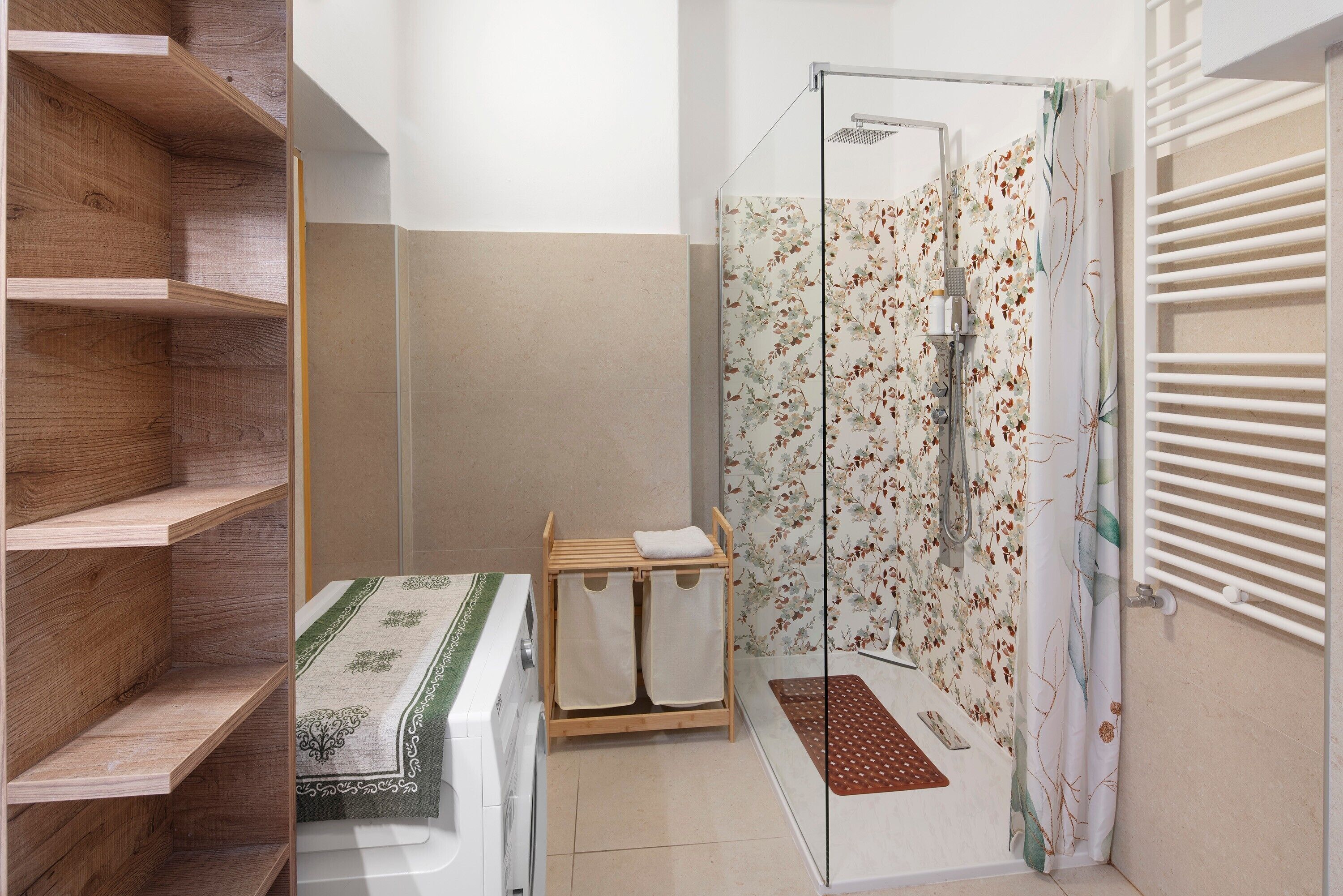Een badkamer met een douche, een houten plankunit en een klein tafeltje met handdoeken.