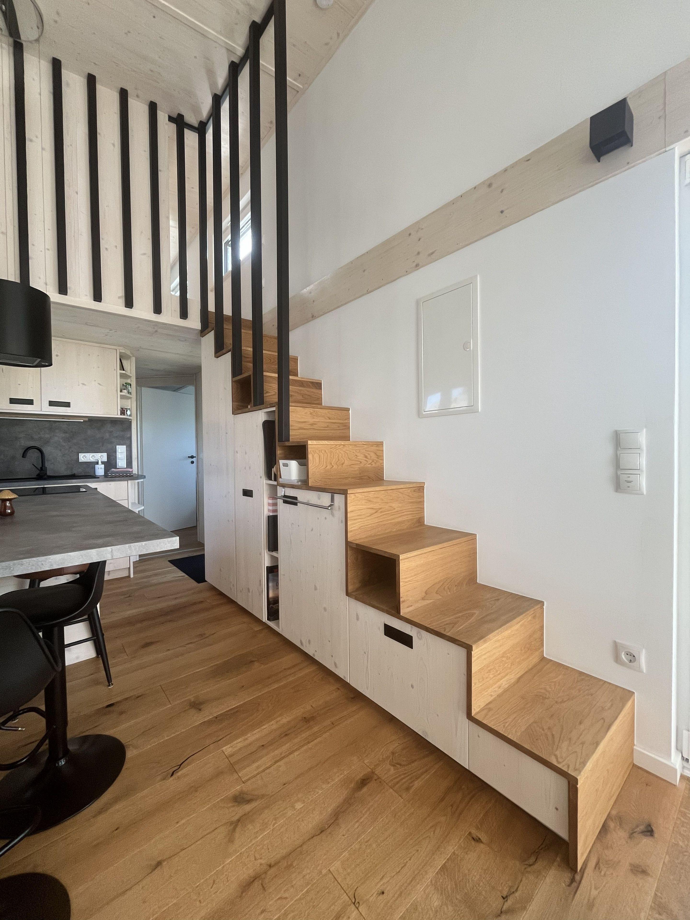 Treppe zur Schlafnische mit Schränken und Regalen