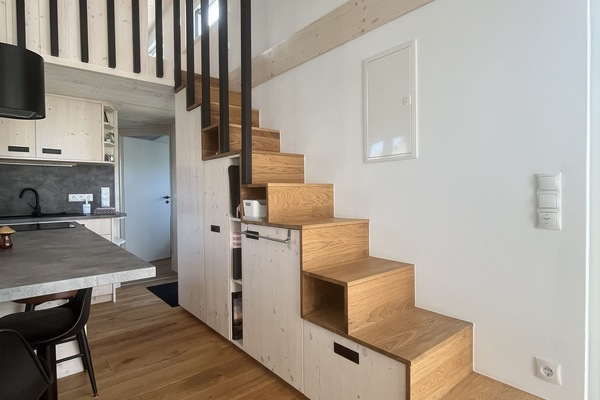Treppe zur Schlafnische mit Schränken und Regalen