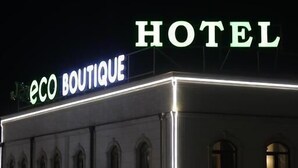 Um edifício com sinalização iluminada que diz "eco BOUTIQUE HOTEL".