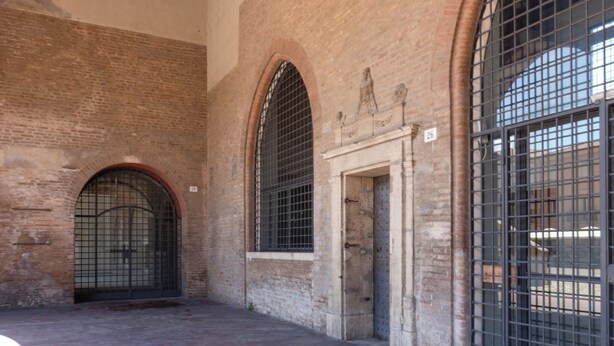 A brick building with arched windows and a metal gate. - Designer loft in a central location with Jacuzzi in the bedroom (Rimini)