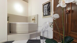 A bathroom with a black and white checkered floor, a white bathtub, and a wooden cabinet. - Designer loft in a central location with Jacuzzi in the bedroom (Rimini)