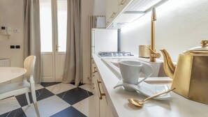 A modern kitchen with a white countertop, a gas stove, a white kettle, and a gold-colored kettle. - Designer loft in a central location with Jacuzzi in the bedroom (Rimini)