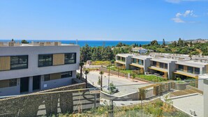 A modern building with multiple balconies overlooking a coastal area. - Townhouse with sea views Evergreen Homes (Mijas Costa)