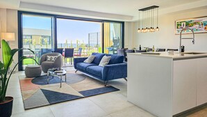 A modern living room with a sofa, coffee table, and a view of the outdoors. - Townhouse with sea views Evergreen Homes (Mijas Costa)