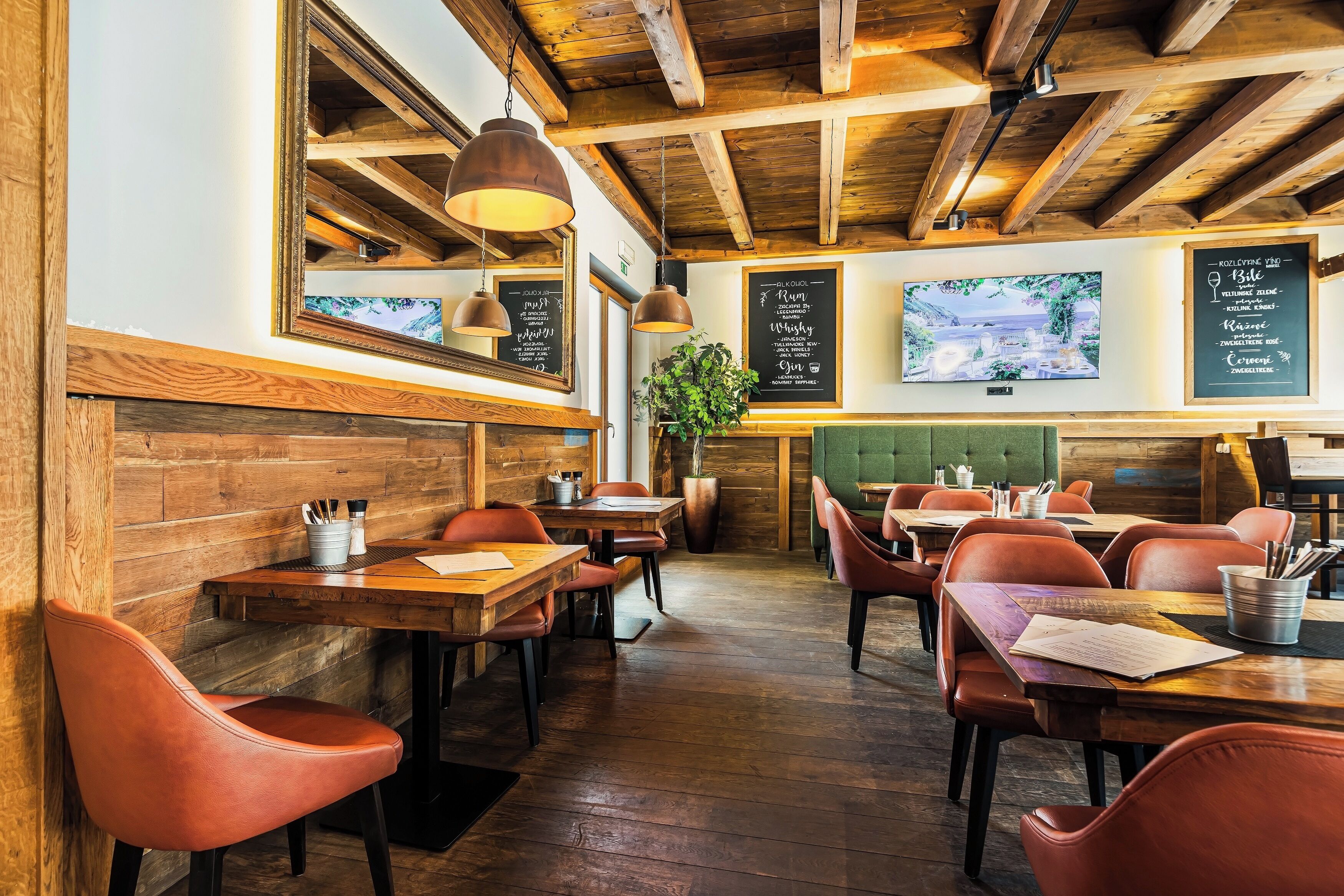 A restaurant interior with wooden beams, tables, chairs, and a menu board.