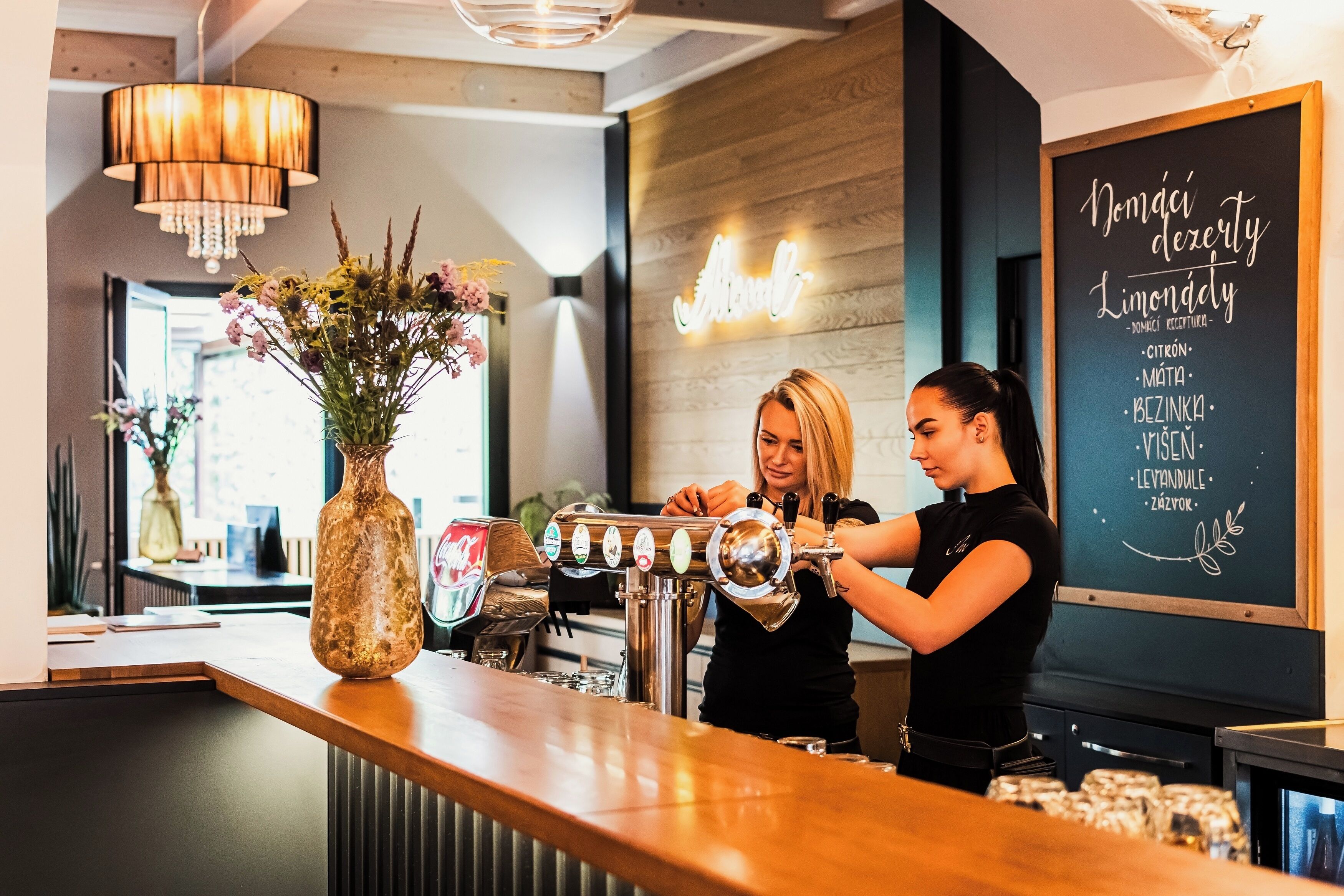 A barista preparing coffee at a counter with a chalkboard menu listing various drinks.