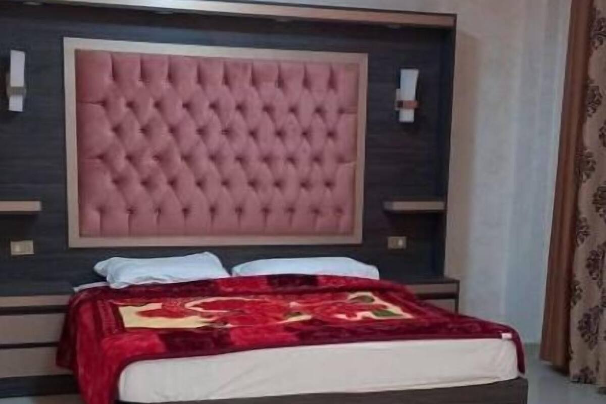 A bedroom with a large bed, a tufted headboard, and a modern design.