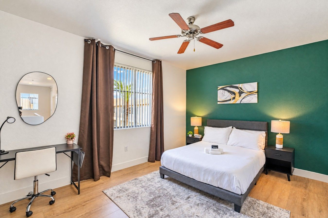 Une chambre d’hôtel équipée d’un lit, d’un bureau, d’une chaise et d’un ventilateur de plafond.