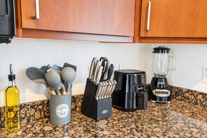A kitchen counter with a coffee maker, a blender, a bottle of olive oil, and a utensil holder. - Walk To Westgate, Pool, Gym, WD & Free Parking (Glendale)