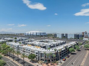 A modern urban area with a large stadium and multi-story buildings. - Walk To Westgate, Pool, Gym, WD & Free Parking (Glendale)