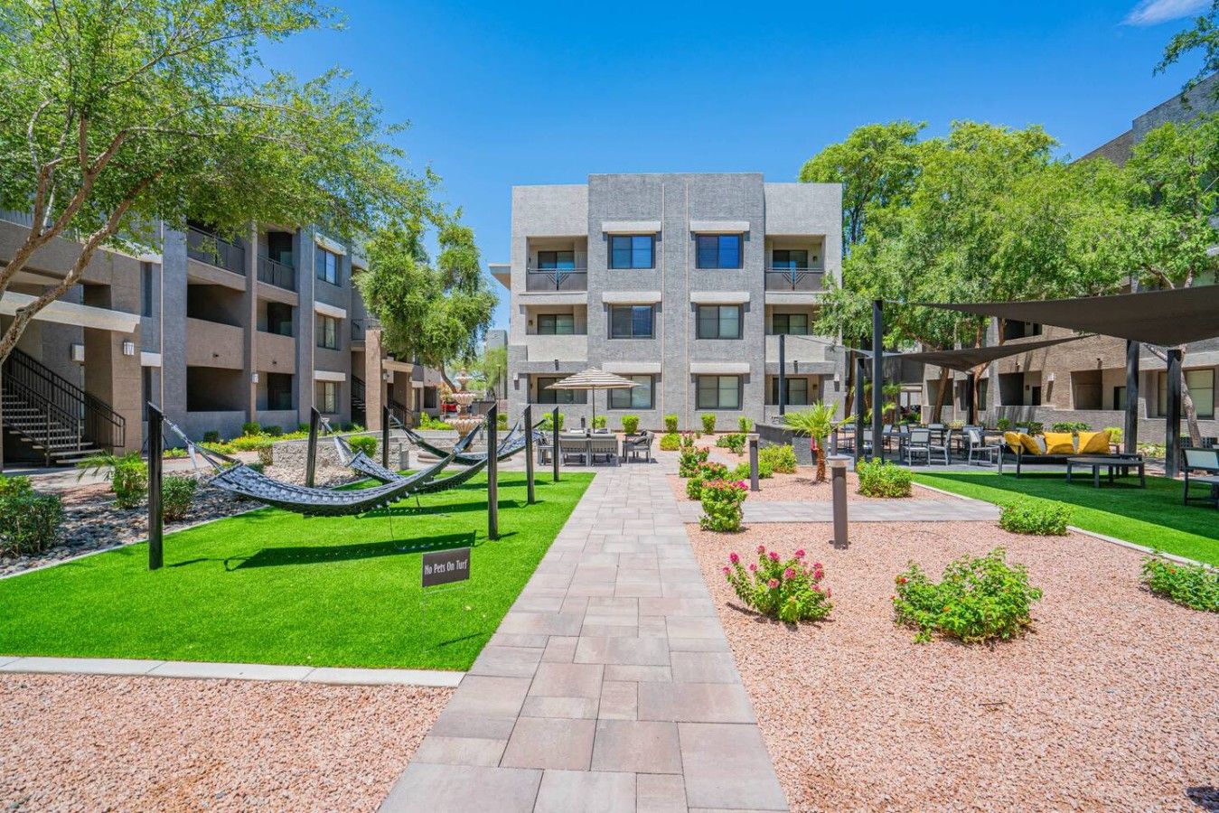 A modern building with a central courtyard, outdoor seating, and a hammock.