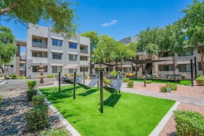 A courtyard with a pool, hammocks, and a fountain. - Lavish 2BD| Walk to Westgate+Pool+Gym+W/D (Glendale)