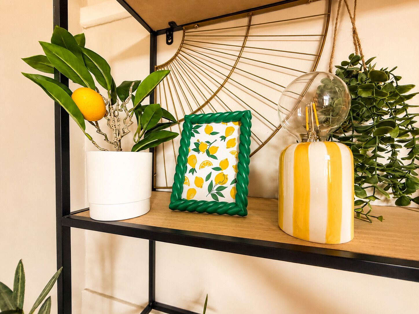 Une étagère avec une plante en pot, un tableau encadré et un vase décoratif.