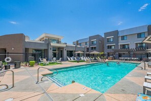 A swimming pool area with lounge chairs and a poolside deck. - Contemporary Condo at Westgate | Pool, Gym & W/D (Glendale)