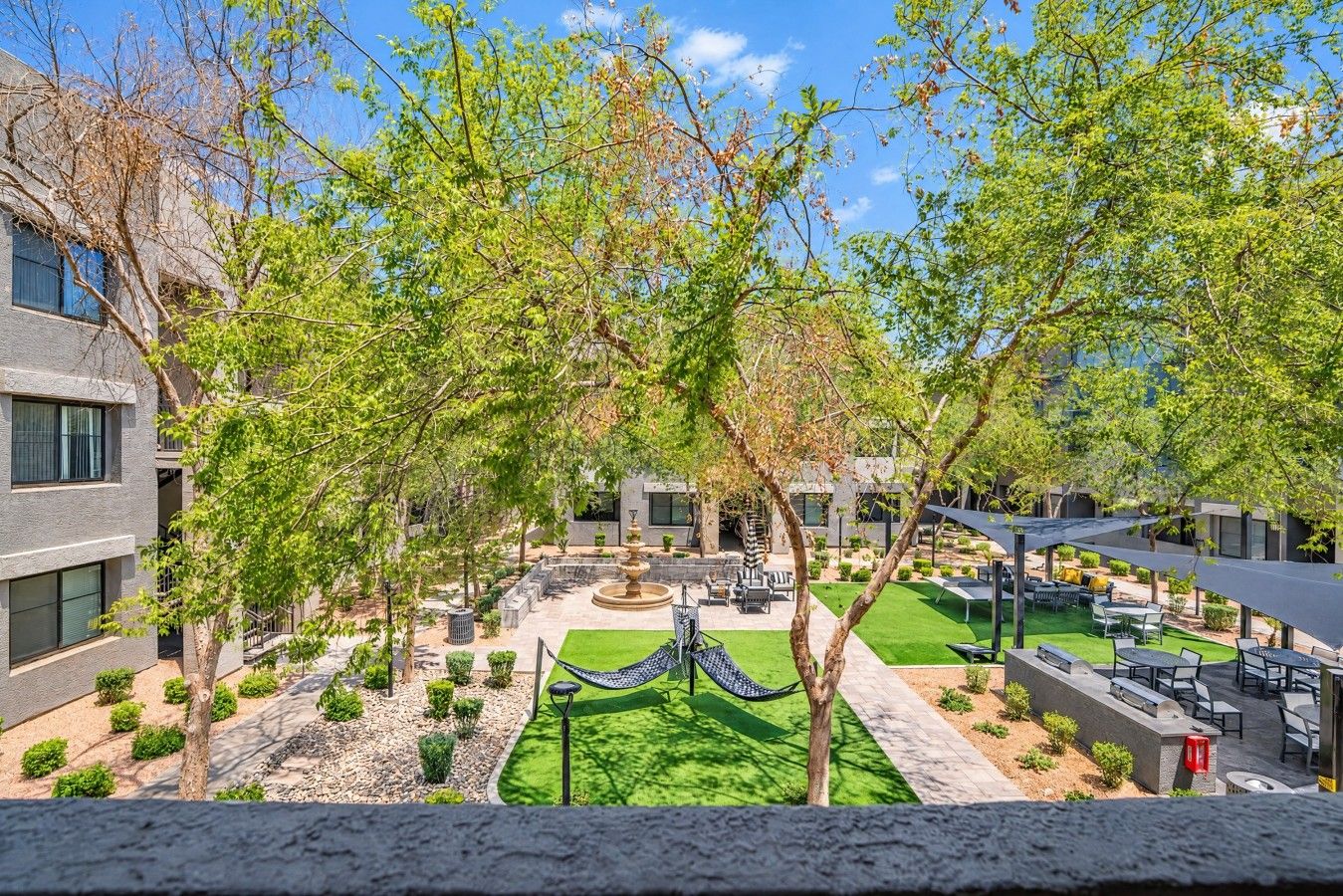 A courtyard with a fountain, seating areas, and a hammock.
