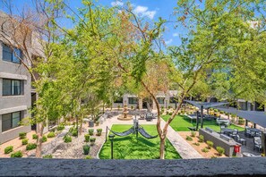 A courtyard with a fountain, seating areas, and a hammock.