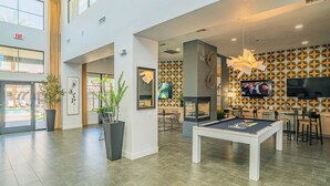 A modern indoor space with a pool table, dining area, and a TV screen. - Clean Westgate | Pool, Gym W/D Hot Tub Parking (Glendale)